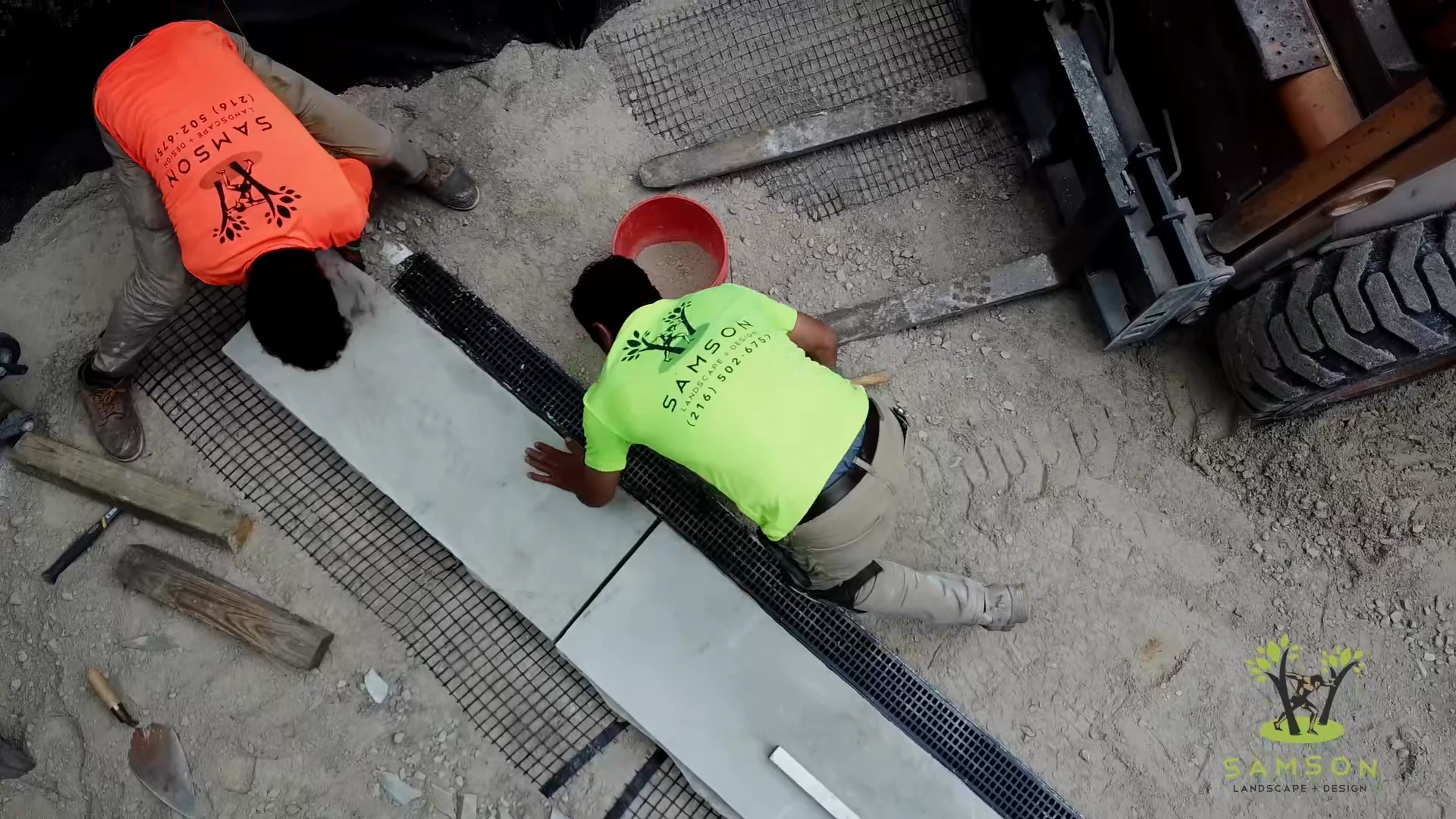Crew bedding a large stone slab, seen from overhead